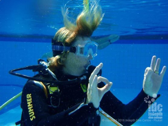 PADI Scuba Instructor signals OK to her students in the pool